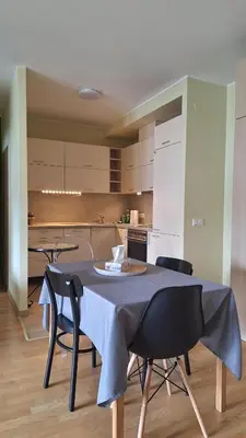 a kitchen with a table and chairs in a room at Butas1 in Vilnius
