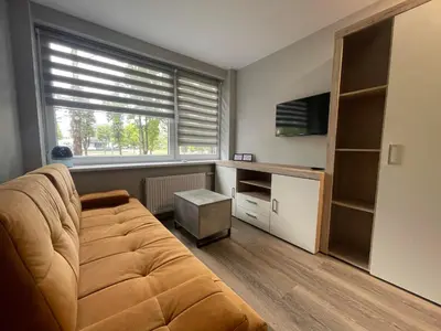 a living room with a couch and a window at 24h self check-in COZY VISIT Studio3 on the first floor in Kaunas