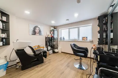 a hair salon with two chairs and a window at Svečių namai Imperija in Šiauliai