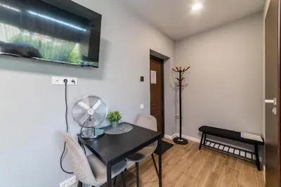 a living room with a table and a fan at Svečių namai Imperija in Šiauliai