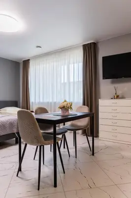 a dining room with a table and chairs and a bedroom at Svečių namai Imperija in Šiauliai