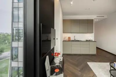 a kitchen with white cabinets and a large window at River home in Kaunas