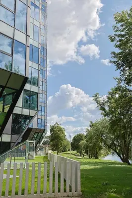 a glass building with a fence in front of it at River home in Kaunas