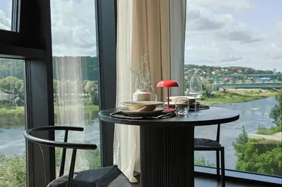 a table in a room with a large window at River home in Kaunas