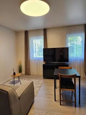 a living room with a tv and a couch and a table at VV apartamentai in Kaunas