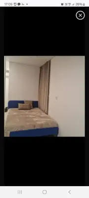 a small bedroom with a bed with blue sheets at VV apartamentai in Kaunas