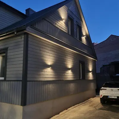 a house with lights on the side of it at VV apartamentai in Kaunas