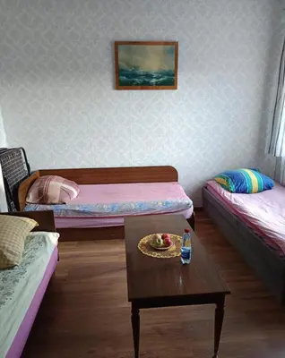 a room with two beds and a table with a plate of food at Cosy Charming Guest House in central of Marijampole in Marijampolė
