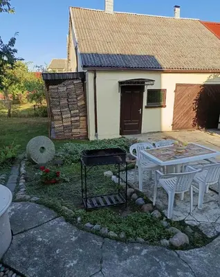 a backyard with a table and chairs and a grill at Cosy Charming Guest House in central of Marijampole in Marijampolė