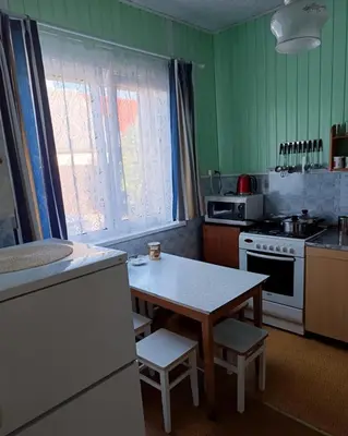 a kitchen with green walls and a table with chairs at Cosy Charming Guest House in central of Marijampole in Marijampolė