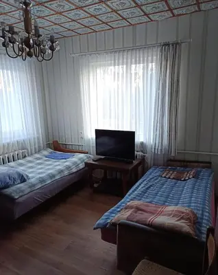 a room with two beds and a tv in it at Cosy Charming Guest House in central of Marijampole in Marijampolė