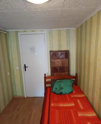 a small bedroom with a red bed and a white door at Cosy Charming Guest House in central of Marijampole in Marijampolė