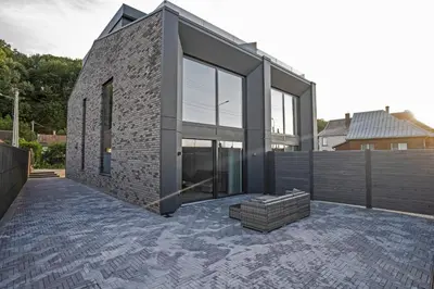a brick house with glass doors on a patio at MARVEL apartamentai in Kaunas