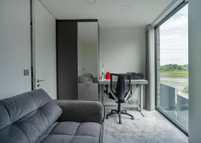 a living room with a couch and a desk at MARVEL apartamentai in Kaunas