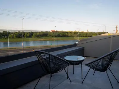 two chairs and a table on a balcony with a view at MARVEL apartamentai in Kaunas