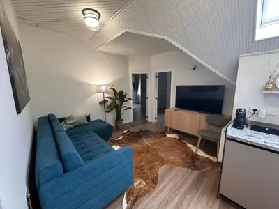 a living room with a blue couch and a rug at Aqua Lagoon Druskininkai in Druskininkai