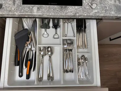a white drawer filled with utensils in a kitchen at Aqua Lagoon Druskininkai in Druskininkai