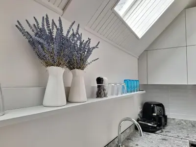 two white vases sitting on a shelf in a kitchen at Aqua Lagoon Druskininkai in Druskininkai