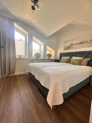 a bedroom with a large bed and two windows at Aqua Lagoon Druskininkai in Druskininkai