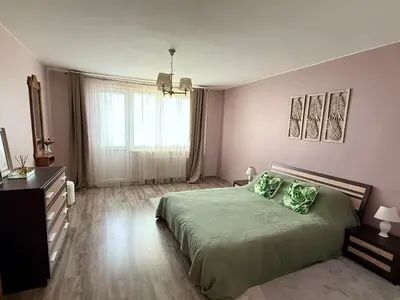 a bedroom with a green bed and a window at Central Modern Two Bedroom Apartment in Druskininkai
