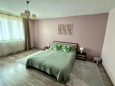 a bedroom with a large bed with two green pillows at Central Modern Two Bedroom Apartment in Druskininkai