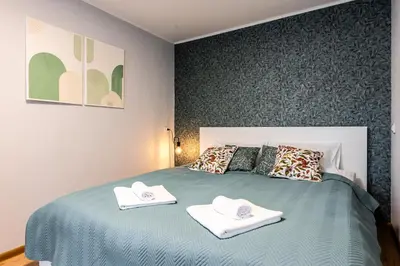 a bedroom with a bed with two towels on it at Cozy Coner Apartments in Kaunas