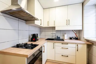 a kitchen with white cabinets and a stove top oven at Cozy Coner Apartments in Kaunas