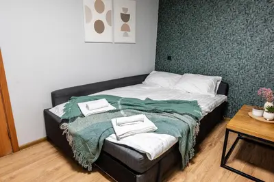 a small bedroom with a bed with a green blanket at Cozy Coner Apartments in Kaunas