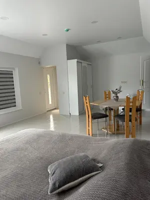 a bedroom with a bed and a table and chairs at Apartamentai LUKA in Marijampolė
