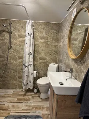 a bathroom with a toilet and a sink and a mirror at Apartamentai LUKA in Marijampolė