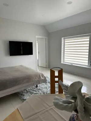 a bedroom with a bed and a tv on the wall at Apartamentai LUKA in Marijampolė