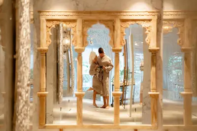 a man and a woman standing in front of a mirror at Shanti Resort & Deluxe SPA in Sarboriškės I