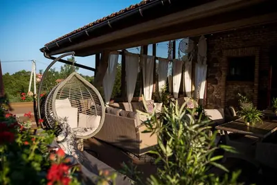 a swing on a porch with plants and flowers at Shanti Resort & Deluxe SPA in Sarboriškės I