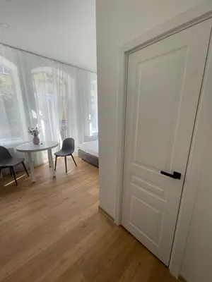 a room with a door and a table and a bed at River House City center in Kaunas