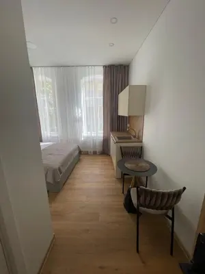 a bedroom with a bed and a table and a chair at River House City center in Kaunas