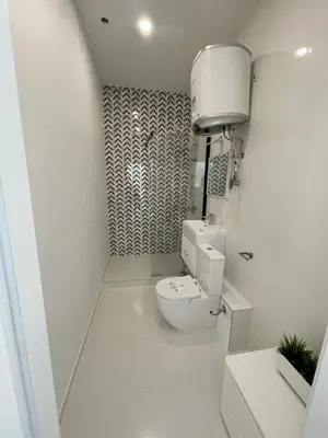 a white bathroom with a toilet and a sink at River House City center in Kaunas