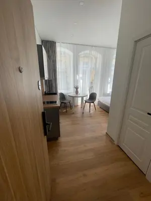 a hallway with a living room with a table and chairs at River House City center in Kaunas