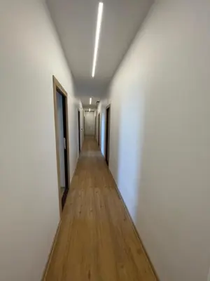 a long hallway with white walls and a wooden floor at River House City center in Kaunas