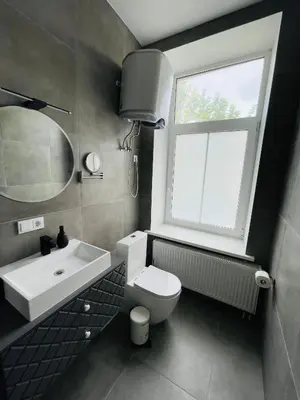 a bathroom with a sink and a toilet and a window at River House City center in Kaunas