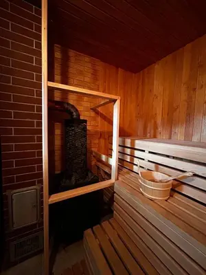 an inside of a wooden sauna with a fireplace at GobeHouse Sodyba in Vilkanastrai
