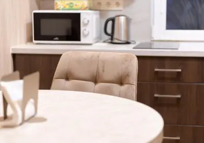 a kitchen with a table and a microwave at GobeHouse Sodyba in Vilkanastrai