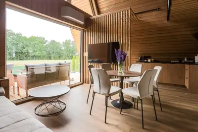 a living room with a table and chairs and a kitchen at Poilsio Vingis in Liūnai