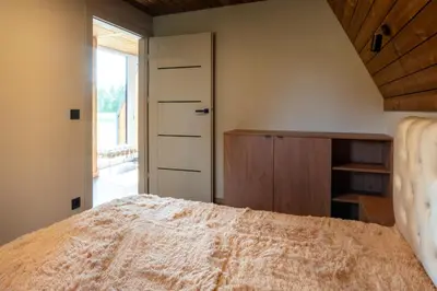 a bedroom with a bed and a closet and a window at Poilsio Vingis in Liūnai
