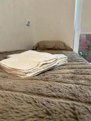 a pile of blankets sitting on top of a bed at Baltijos Apartment in Kaunas
