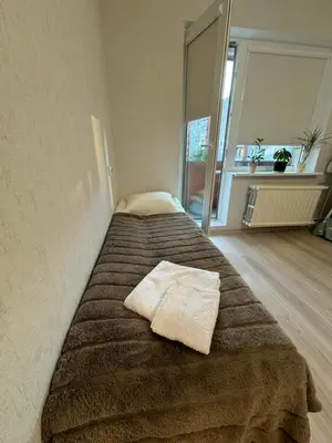 a bed with two towels on it in a room at Baltijos Apartment in Kaunas