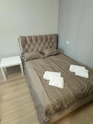 a bed with two towels on it in a room at Baltijos Apartment in Kaunas
