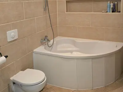 a bathroom with a tub and a toilet and a sink at Cozy & Silent Apartment in Vilnius