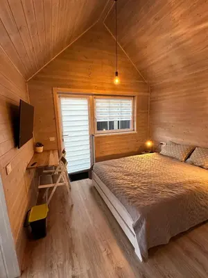 a bedroom with a bed in a wooden cabin at Atostogu namelis in Anykščiai
