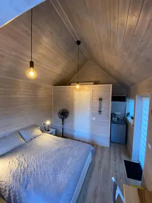 a bedroom with a bed and a wooden ceiling at Atostogu namelis in Anykščiai