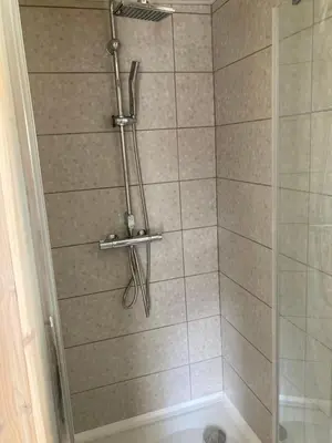 a shower with a glass door in a bathroom at Atostogu namelis in Anykščiai